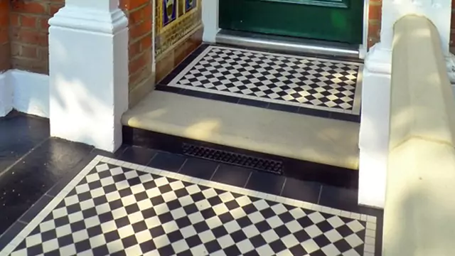 Black and White tiles in small porch, with stone threshold and glazed wall tile panels.