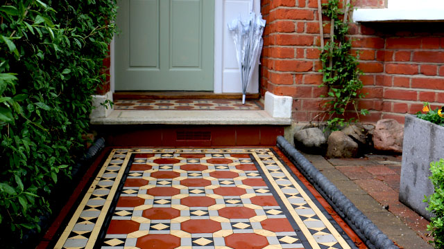 Custom cut red octagon tiles form part of a colourful mosaic path design.