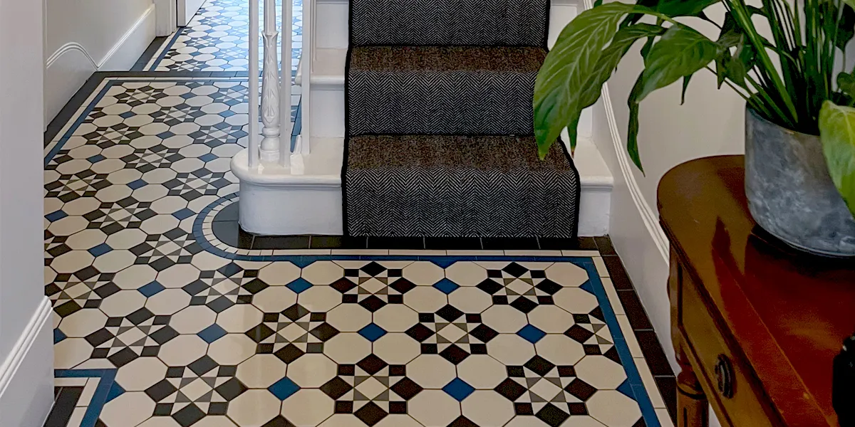 Traditional Victorian hallway with mosaic floor in deep blue, white, black and grey.