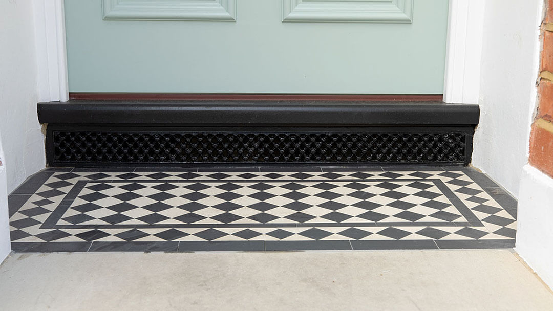 Reproduction Victorian Daisy Grate Ventilation Grill positioned under porch step.