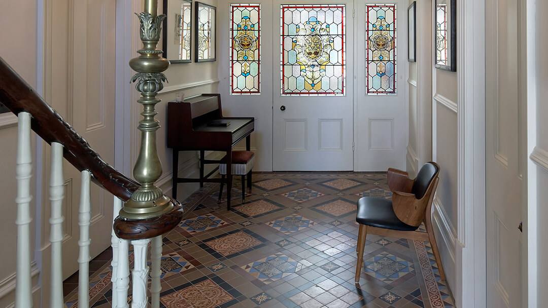 A combination of new and salvaged encaustic floor tiles in a grand entryway.