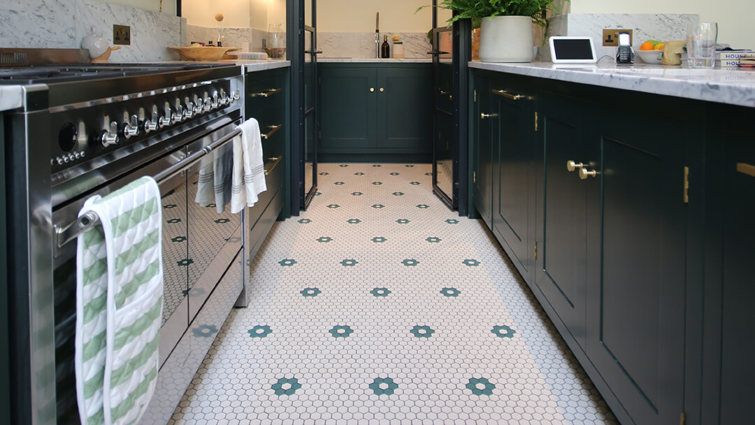 Contemporary kitchen featuring a floor of 25mm super white hexagons with a dark green floral motif.