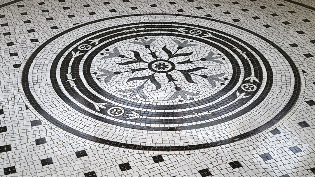 Art Nouveau influenced circular motif of marble mosaic for a bathroom floor.