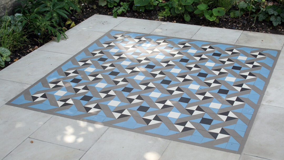 Modern geometric pattern in black, white, blue and grey, as part of a garden patio.